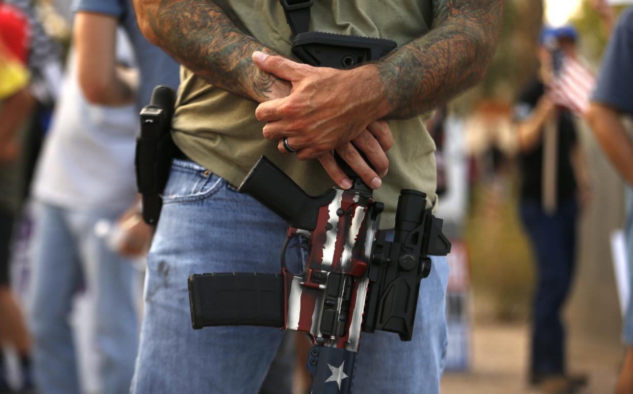 A pro-police supporter carries two guns and extra magazines in his back pockets during a pro-police rally and Black Lives Matter counter protest in Gilbert on Aug. 27, 2020.