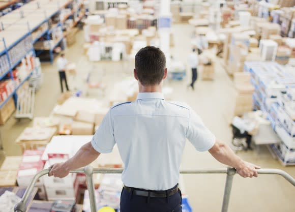 A shipping supervisor surveys boxes to be sent.