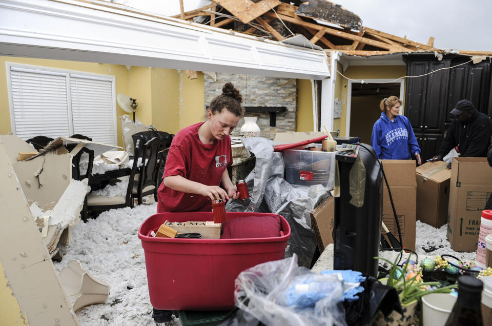 <p>Ivy Thigpen helps sort out kitchenware in Mike and Phillis Schell’s destroyed house Tuesday, March 20, 2018, in Ardmore, Ala., after a violent storm went swept through the area the night before. (Photo: Jeronimo Nisa/The Decatur Daily via AP) </p>