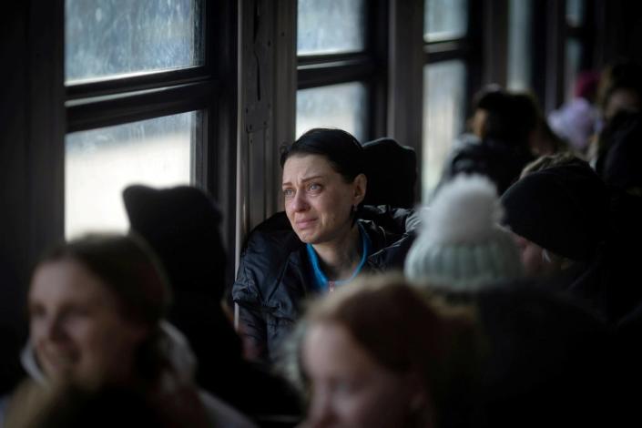 A woman cries as an evacuation train from Lviv, Ukraine, pulls out from the station towards Przemysl, Poland (Adam Gray/SWNS)