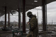 A Ukrainian serviceman patrols area near the Antonovsky Bridge which was destroyed by Russian forces after withdrawing from Kherson, Ukraine, Thursday, Dec. 8, 2022. (AP Photo/Evgeniy Maloletka)
