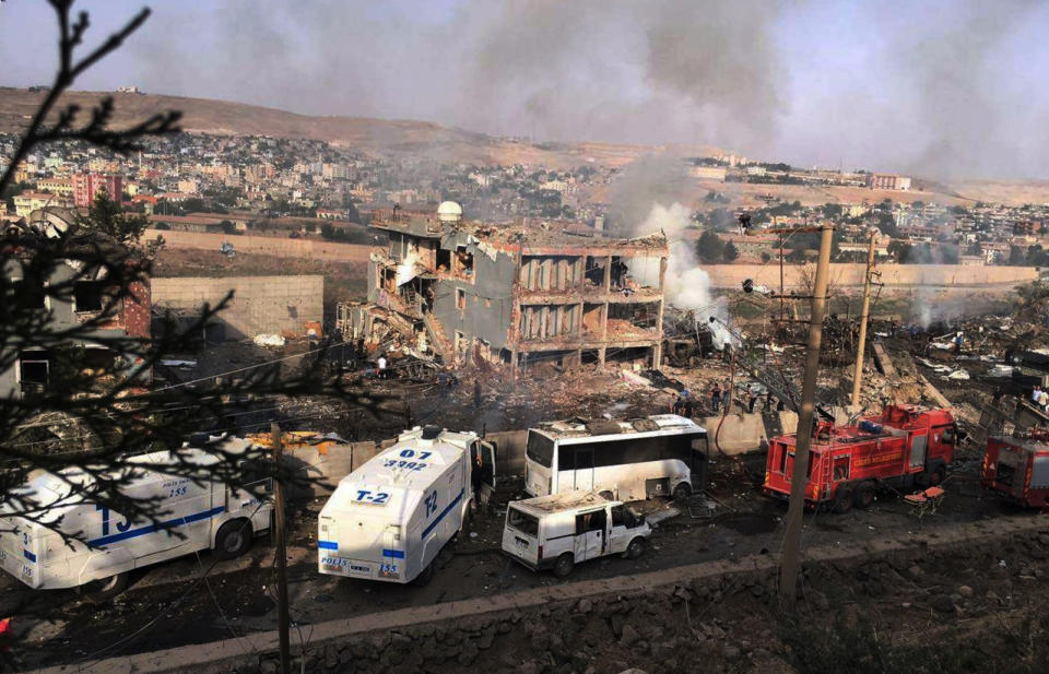 Smoke still rises from the scene after Kurdish militants attacked a police checkpoint in Cizre, southeast Turkey, Friday, Aug. 26, 2016, with an explosives-laden truck, killing several police officers and wounding dozens more, according to reports from the state-run Anadolu news agency. (DHA via AP)