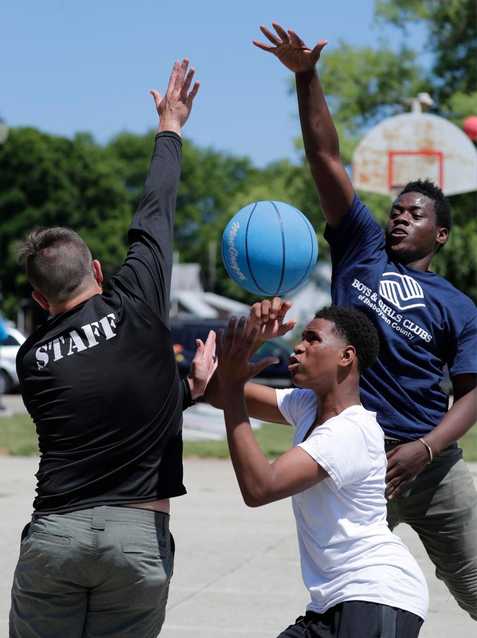 Boys and Girls Club's Andrew Jakus, left, tries to block Travionte Coleman, 14, of Milwaukee, make a shot by Jalen Robinson, of Sheboygan, Saturday, June 19, 2021.