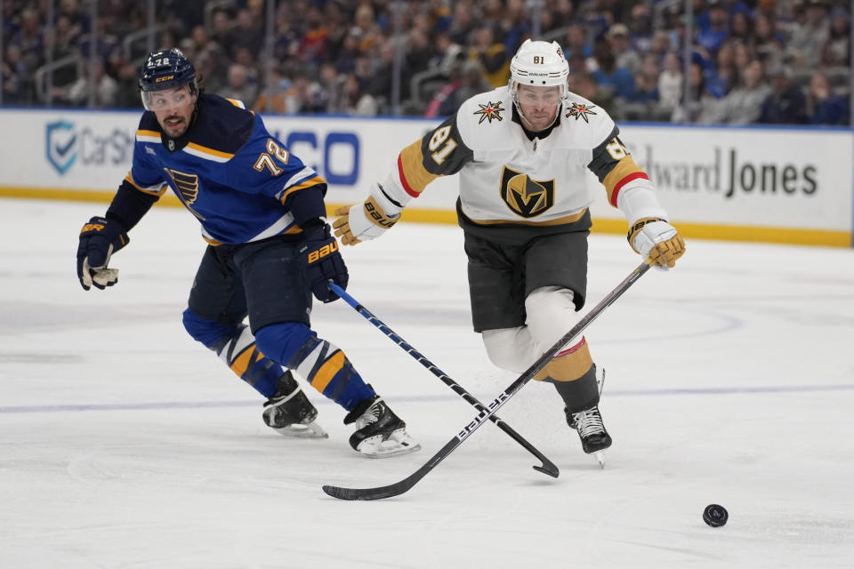 St. Louis Blues' Justin Faulk (72) and Vegas Golden Knights' Jonathan Marchessault (81) chase after a loose puck during the second period of an NHL hockey game Sunday, March 12, 2023, in St. Louis. (AP Photo/Jeff Roberson)