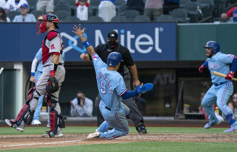 CORRECTS TO JOSE TREVINO NOT WILLIE CALHOUN - Texas Rangers' Isiah Kiner-Falefa (9) scores on a go-ahead RBI-single by teammate Brock Holt as home plate umpire Brian O'Nora and Boston Red Sox catcher Kevin Plawecki look on while Rangers' Jose Trevino, right, celebrates during the eighth inning of a baseball game Sunday, May 2, 2021, in Arlington, Texas. (AP Photo/Jeffrey McWhorter)