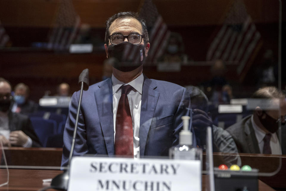 American flags are reflected in a protective shield as Treasury Secretary Steven Mnuchin testifies during a House Financial Services Committee hearing on the coronavirus response on Capitol Hill in Washington, Tuesday, June 30, 2020. (Tasos Katopodis/Pool via AP)