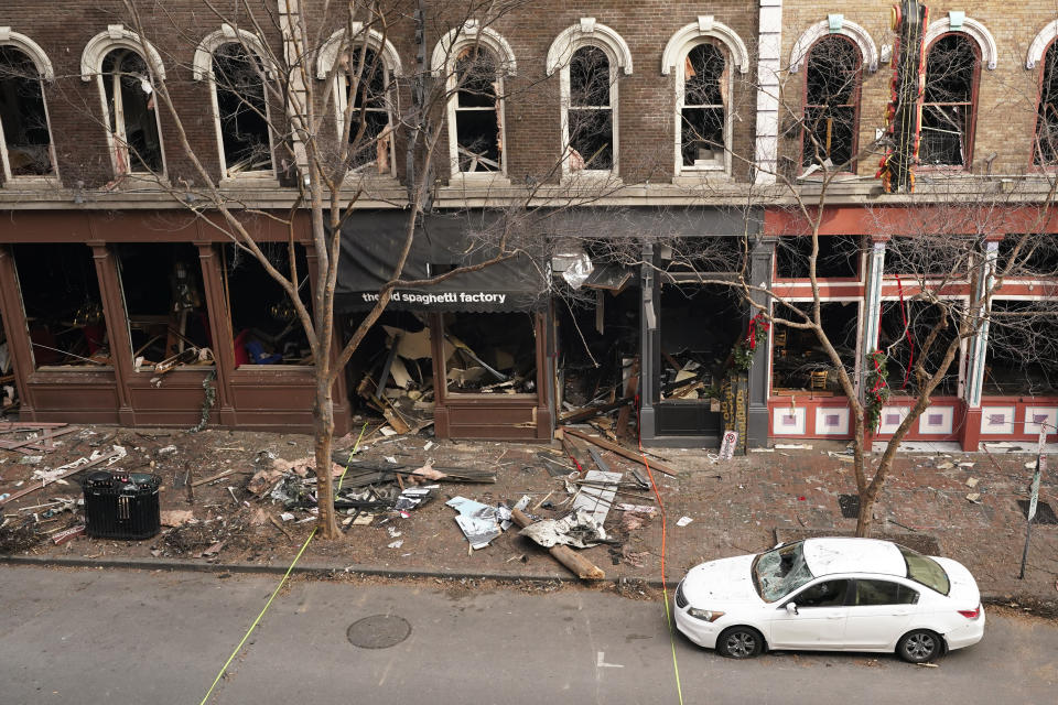 Debris remains on the sidewalk in front of buildings damaged in a Christmas Day explosion Tuesday, Dec. 29, 2020, in Nashville, Tenn. Officials have named 63-year-old Anthony Quinn Warner as the man behind the bombing in which he was killed, but the motive has remained elusive. (AP Photo/Mark Humphrey)