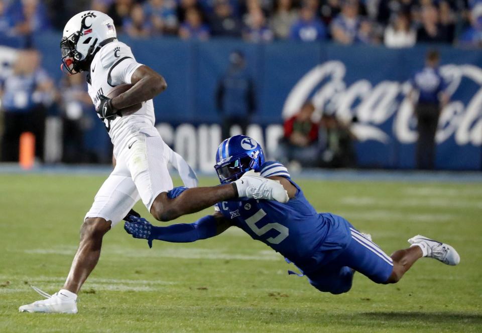 Brigham Young Cougars cornerback Eddie Heckard (5) tackles Cincinnati Bearcats wide receiver Xzavier Henderson (8) during the second half of a football game at LaVell Edwards Stadium in Provo on Friday, Sept. 29, 2023. BYU won 35-27. | Kristin Murphy, Deseret News