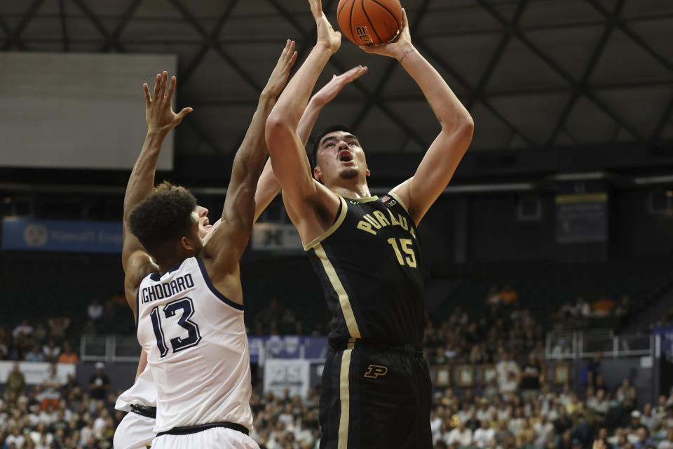 Marquette forward Oso Ighodaro (13) and guard Tyler Kolek try to guard Purdue center Zach Edey (15) during the first half of an NCAA college basketball game, Wednesday, Nov. 22, 2023, in Honolulu. (AP Photo/Marco Garcia)