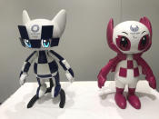 In this Thursday, July 18, 2019, photo, robots of mascots of Olympics "Miraitowa," left, and Paralympics "Someity" are shown to the media at Toyota Motor Corp. headquarters in Tokyo. The mascot robots’ eyes change to the images of stars and hearts. The Japanese automaker Toyota, a major Olympic sponsor, is readying various robots for next year’s Tokyo Olympics. (AP Photo/Yuri Kageyama)