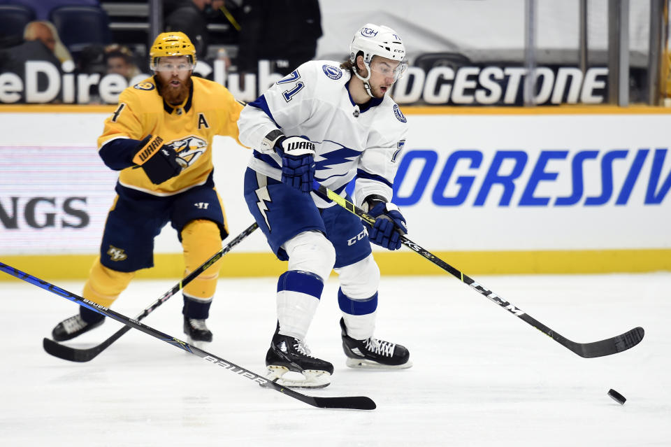 Tampa Bay Lightning center Anthony Cirelli (71) moves the puck in front of Nashville Predators defenseman Ryan Ellis (4) during the first period of an NHL hockey game Tuesday, April 13, 2021, in Nashville, Tenn. (AP Photo/Mark Zaleski)
