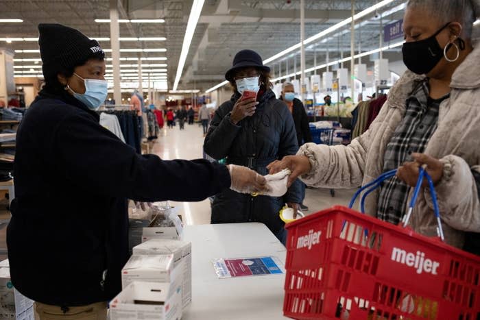 An employee distributes three free N95 masks as part of a government strategy to reduce the spread of COVID-19 at Meijer in Southfield, Michigan, Jan. 25, 2022.