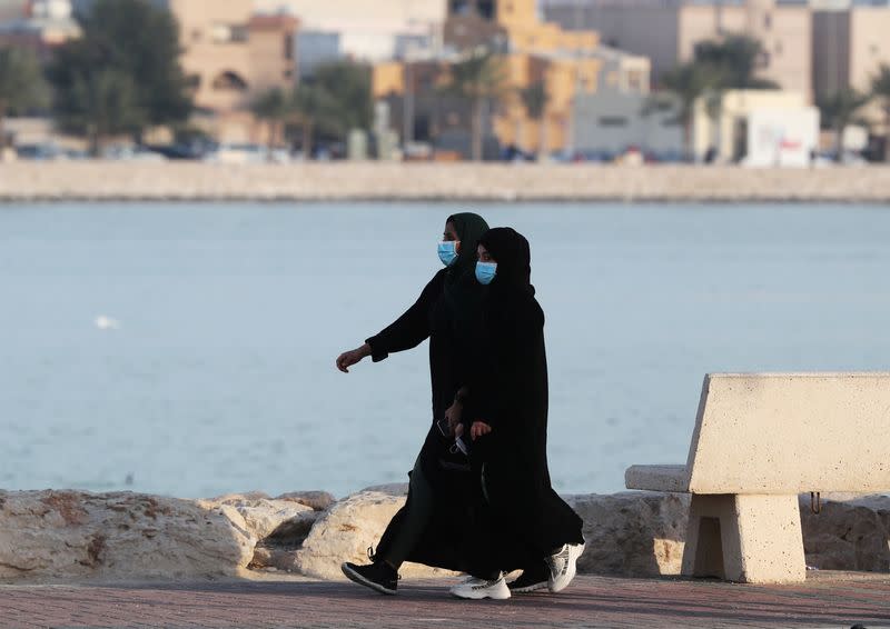 Women wear protective face masks, as they walk, after Saudi Arabia imposed a temporary lockdown on the province of Qatif, following the spread of coronavirus, in Qatif