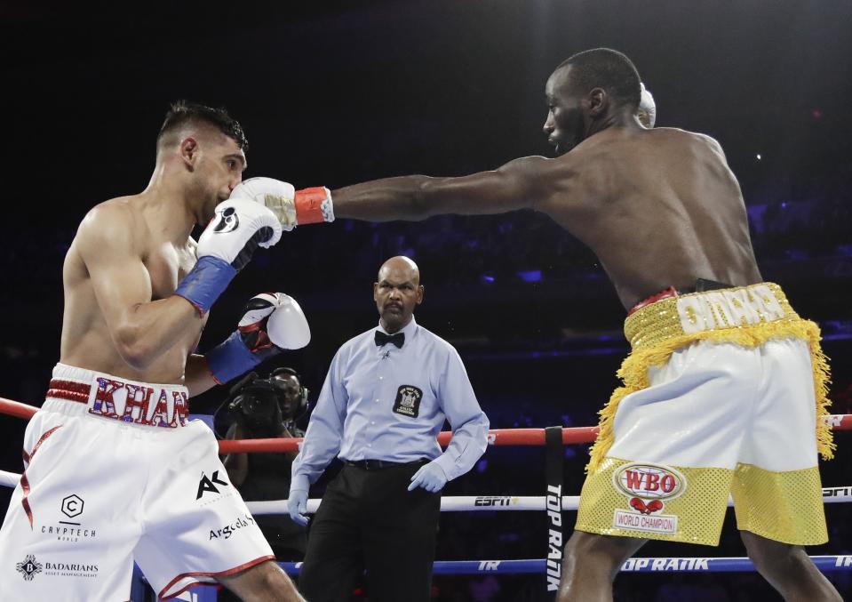 Terence Crawford, right, punches England's Amir Khan during the second round of a WBO world welterweight championship boxing match Sunday, April 21, 2019, in New York. Crawford won the fight. (AP Photo/Frank Franklin II)