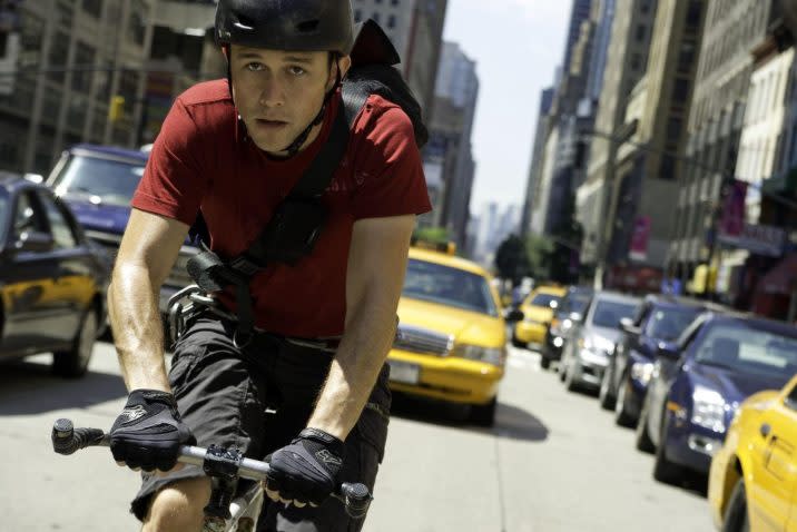 A man on a bike travels through the streets of New York City.