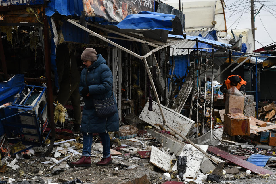 A woman passes by a city market that was damaged following Wednesday's Russian shelling, in Kurakhove, Donetsk region, Ukraine, Thursday, Dec. 8, 2022. (AP Photo/Andriy Andriyenko)
