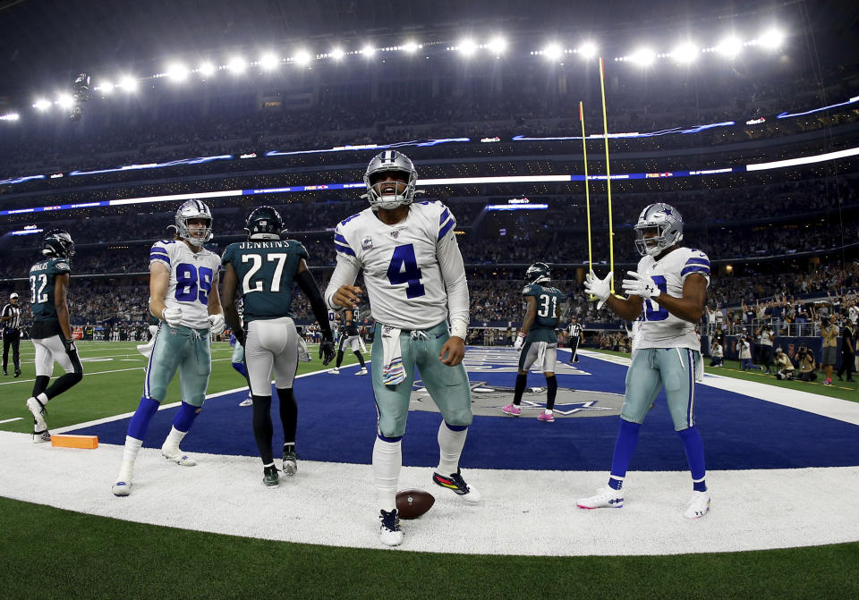 Dallas Cowboys quarterback Dak Prescott (4), Blake Jarwin (89), Randall Cobb (18) celebrate a touchdown scored by Prescott on a running play as Philadelphia Eagles' Malcolm Jenkins (27) walks away in the second half of an NFL football game in Arlington, Texas, Sunday, Oct. 20, 2019. (AP Photo/Ron Jenkins)