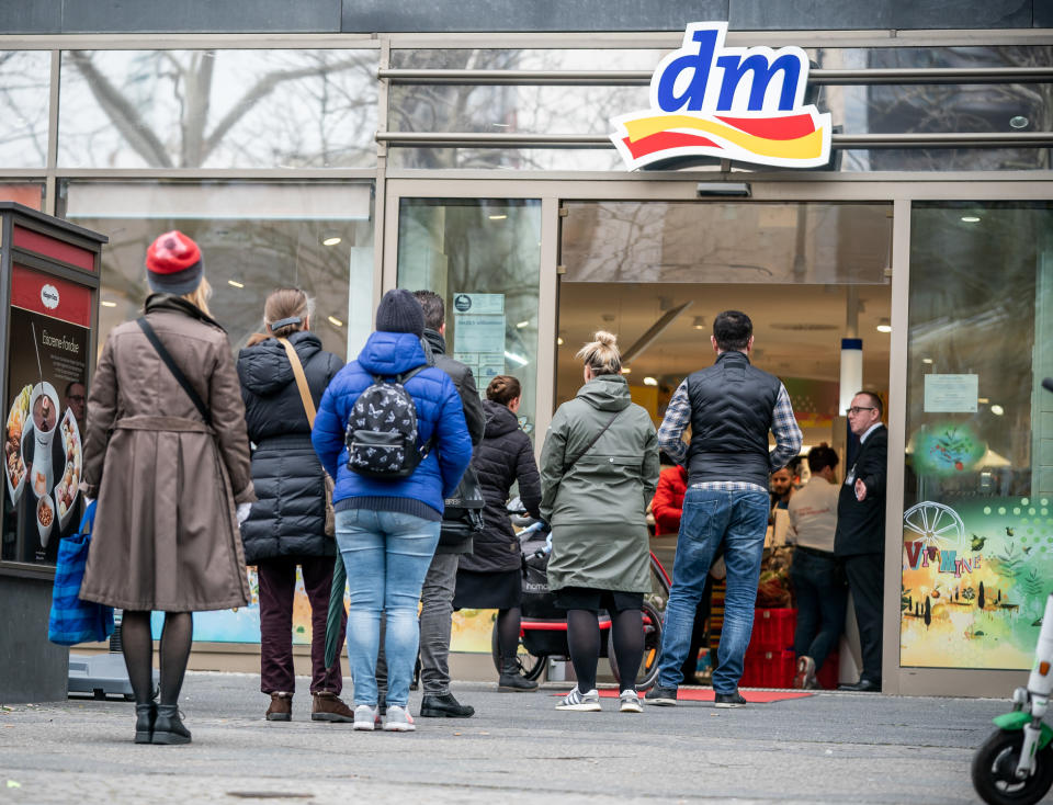 20.03.2020, Berlin: EinkÃ¤ufer stehen in einer Schlange vor dem Drogeriemarkt DM am KurfÃ¼rstendamm und werden durch das Sicherheitspersonal nur einzeln eingelassen. Foto: Michael Kappeler/dpa +++ dpa-Bildfunk +++