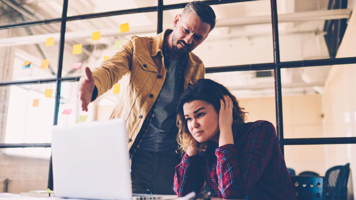 Female student feeling upset with project failure listening to coach critics during meeting in office, irritated leader of company checking work of employee angry about bad ideas and accountings - Image.