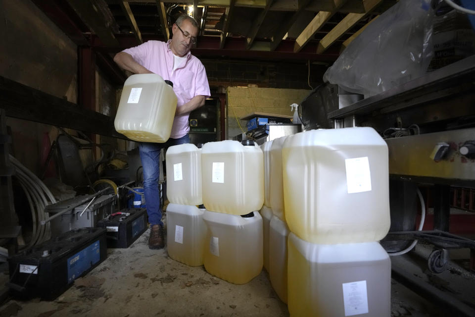 Harry Niazi carries a container of sunflower oil out of storage at Olleys Fish Experience in Herne Hill in London, Thursday, April 21, 2022. Global cooking oil prices have been rising since the COVID-19 pandemic began and Russia's war in Ukraine has sent costs spiralling. It is the latest fallout to the global food supply from the war, with Ukraine and Russia the world’s top exporters of sunflower oil. And it's another rising cost pinching households and businesses as inflation soars. (AP Photo/Kirsty Wigglesworth)