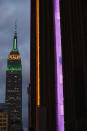 The side of Madison Square Garden, right, is illulminated in gold and purple, colors of the Los Angeles Lakers as the Empire State Building is shown nearby, Sunday, Jan. 26, 2020, in New York. The colors are in memory of retired Lakers star Lobe Bryant, who died in a helicopter crash earlier Sunday in California. (AP Photo/Kathy Willens)