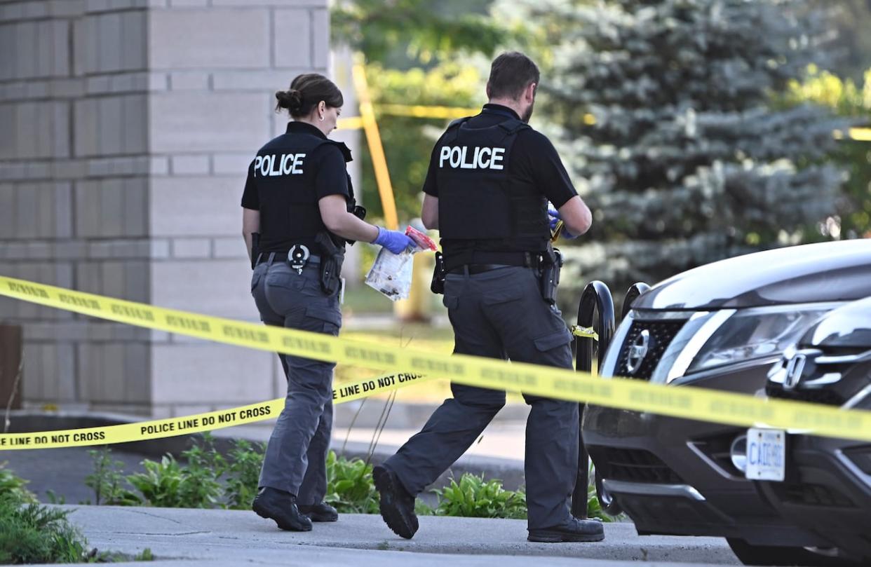 Ottawa police officers collect evidence on Sept. 3, 2023, after a shooting at the Infinity Convention Centre that left two dead. (The Canadian Press - image credit)