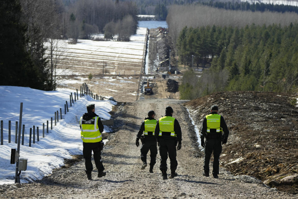 Finland's border guards walk at construction site of the border barrier fence between Finland and Russia near Pelkola border crossing point in Imatra, south-eastern Finland, Friday, April 14, 2023. (AP Photo/Sergei Grits)