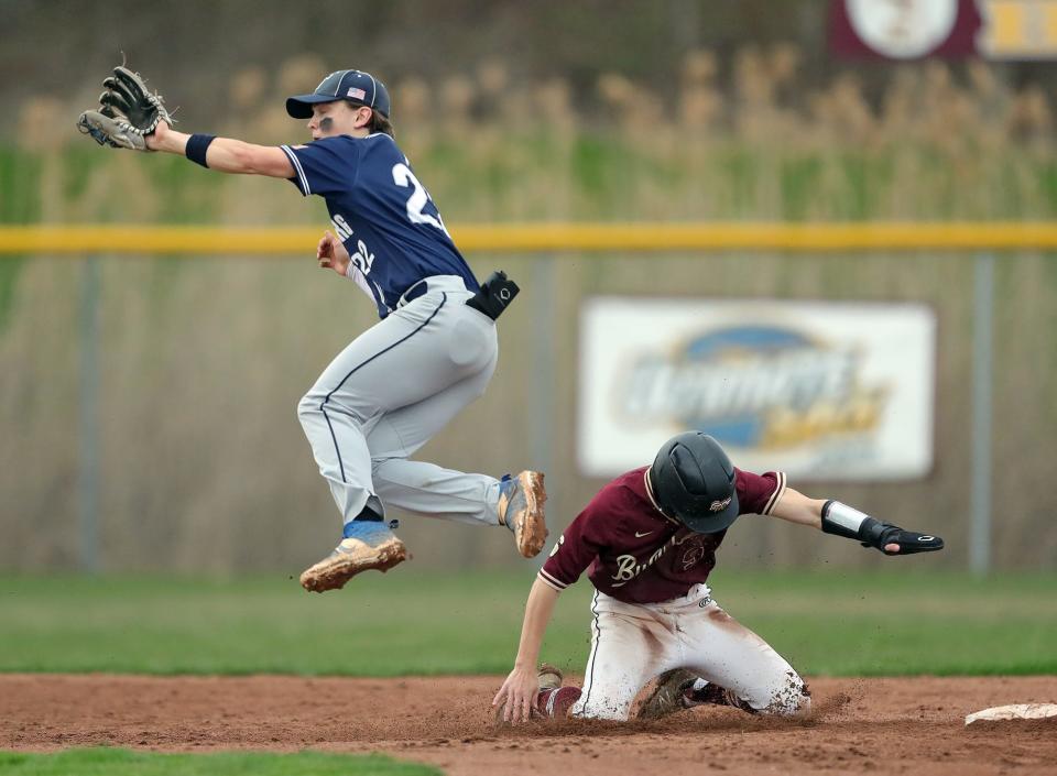 Stow baserunner Carlo DeLorenzo, bottom, dives back to second under Twinsburg shortstop Chris Bryant during the sixth inning of a baseball game on Friday in Stow.
