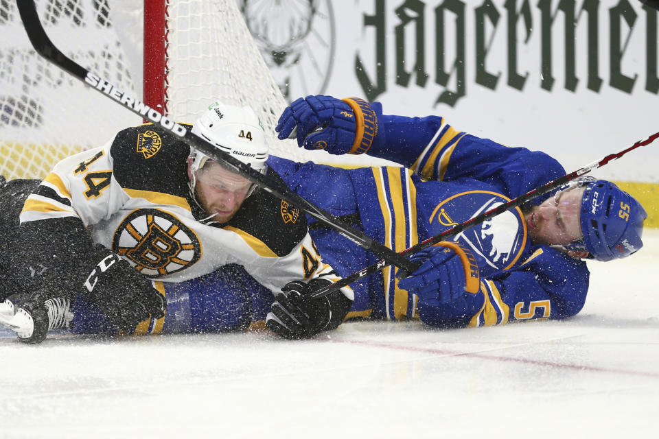 Buffalo Sabres defenseman Rasmus Ristolainen (55) and Boston Bruins defenseman Steven Kampfer (44) crash to the ice during the second period of an NHL hockey game Thursday, April 22, 2021, in Buffalo, N.Y. (AP Photo/Jeffrey T. Barnes)