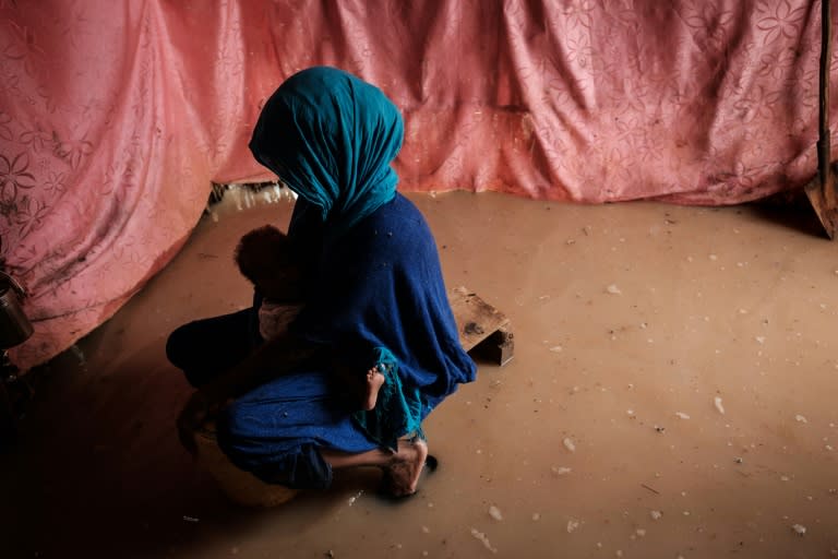 A woman clutches her baby in a storum-flooded shelter at Dadaab in northeastern Kenya, one of the biggest refugee complexes in the world. Dadaab houses 235,000 people, many of them Somalis