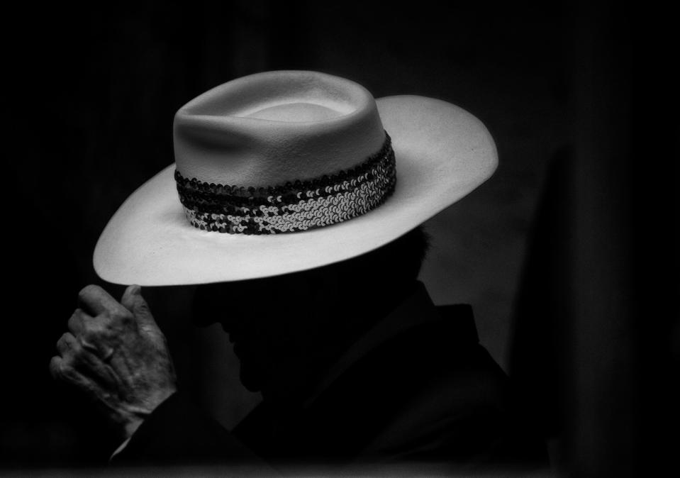 Kentucky music legend Bobby Osborne adjusts his famous super wide hat before going onstage at Meadowgreen Appalachian Music Park, in Clay City, Ky. Nov. 9, 2019.