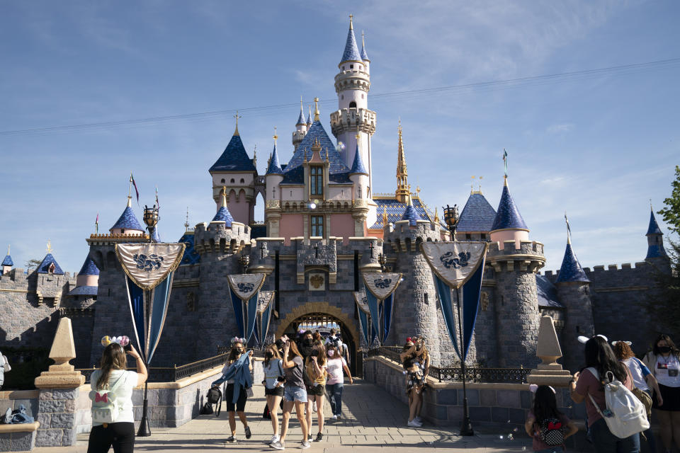 FILE - In this Friday, April 30, 2021, file photo, visitors exit The Sleeping Beauty Castle at Disneyland in Anaheim, Calif. California will offer six "dream vacation" incentives to spur more people to get coronavirus vaccinations, California Gov. Gavin Newsom said Monday, June 14, 2021, on the eve of the state's awarding of $15 million in cash prizes. Goodies in the package include floor seats at an NBA game with the LA Lakers, and tickets to Disneyland, Legoland, SeaWorld and a symphony, he said. (AP Photo/Jae C. Hong, File)