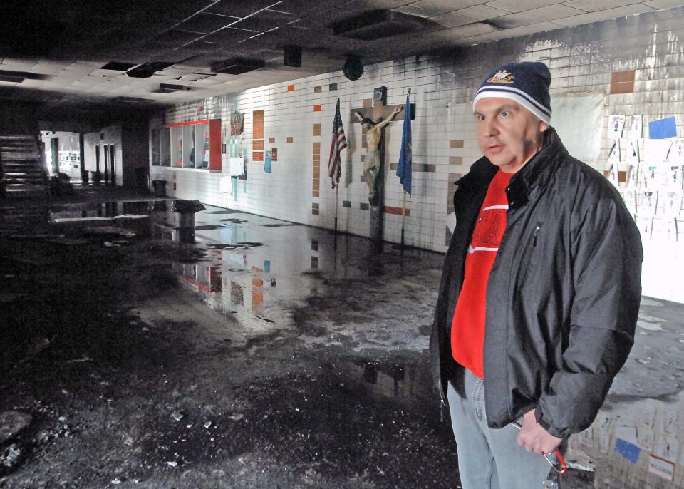 Dickinson Catholic School vice president Rev. Patrick Schumacher stands inside the fire damaged Trinity High School on Wednesday, March 5, 2014. The high school suffered major damage from the fire and will not be in use for the duration of the school year. (AP Photo/The Tribune, Tom Stromme)