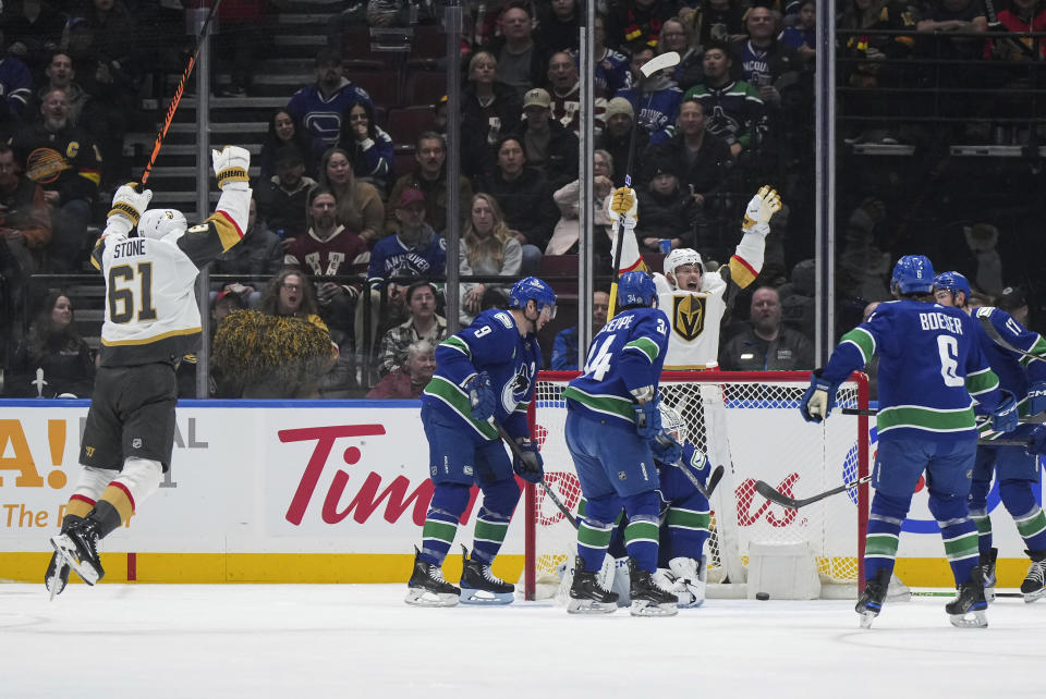 Vegas Golden Knights' Jack Eichel, rear center, and Mark Stone, left, celebrate a goal by Ivan Barbashev against Vancouver Canucks goalie Thatcher Demko during the first period of an NHL hockey game Thursday, Nov 30, 2023, in Vancouver, British Columbia. (Darryl Dyck/The Canadian Press via AP)