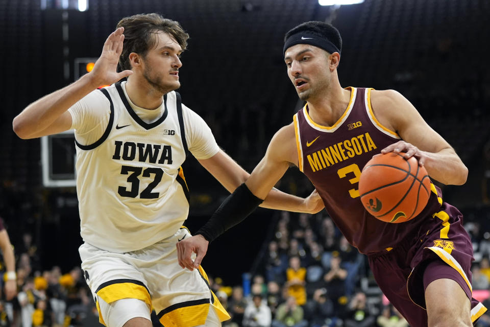 Minnesota forward Dawson Garcia (3) drives to the basket past Iowa forward Owen Freeman (32) during the first half of an NCAA college basketball game, Sunday, Feb. 11, 2024, in Iowa City, Iowa. (AP Photo/Charlie Neibergall)