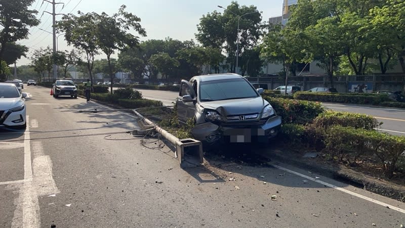 高雄楠梓區20日發生一起自撞車禍，梁姓男子開車行經德民路快車道時，突然向右偏移撞上分隔島，導致燈桿倒下毀損，梁男自稱是一時恍神肇事，酒測值為零，詳細肇責待釐清。（圖／高市楠梓警分局提供）