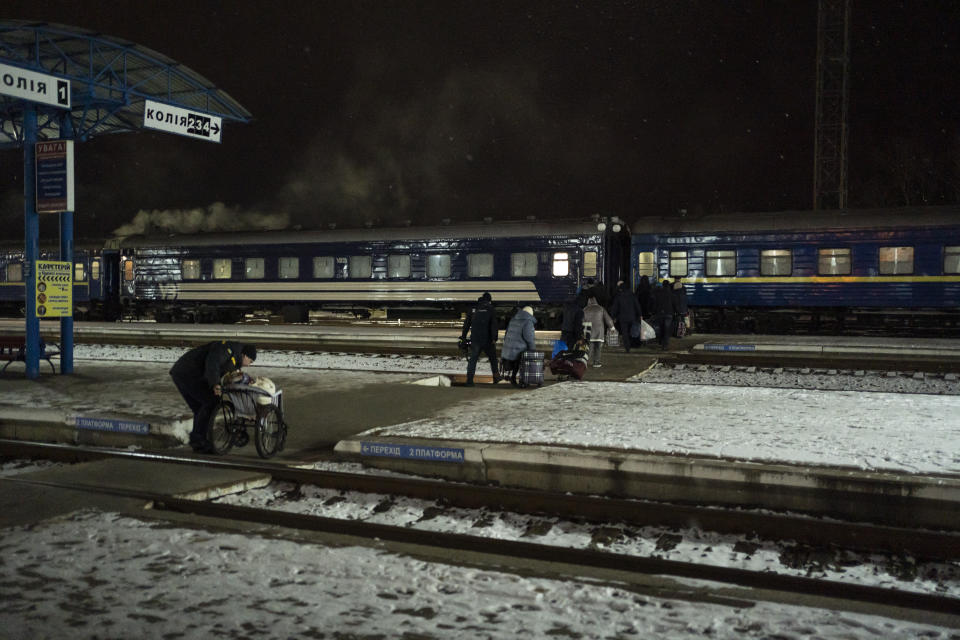 People carry their luggage before boarding an evacuation train in Sumy, Ukraine, Thursday, Nov. 23, 2023. An average of 80-120 people return daily to Ukraine from territories held by Russia through an unofficial crossing point between the two countries amid a brutal war. Most choose this challenging path, even in freezing temperatures, to escape Russian occupation and reunite with their relatives in Ukraine. (AP Photo/Hanna Arhirova)