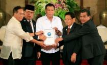 Philippine President Rodrigo Duterte (C) with Moro Islamic Liberation Front (MILF) chairperson Al Haj Murad Ebrahim (2nd from L), Jesus Dureza, Secretary of Peace Process, Ghazali Jaafar (2nd from R), MILF vice-chairman and Mohagher Iqbal, MILF peace panel chairman, hold a draft law of the Bangsamoro Basic Law (BBL) during a ceremony at the Malacanang presidential palace in metro Manila, Philippines July 17, 2017. REUTERS/Romeo Ranoco