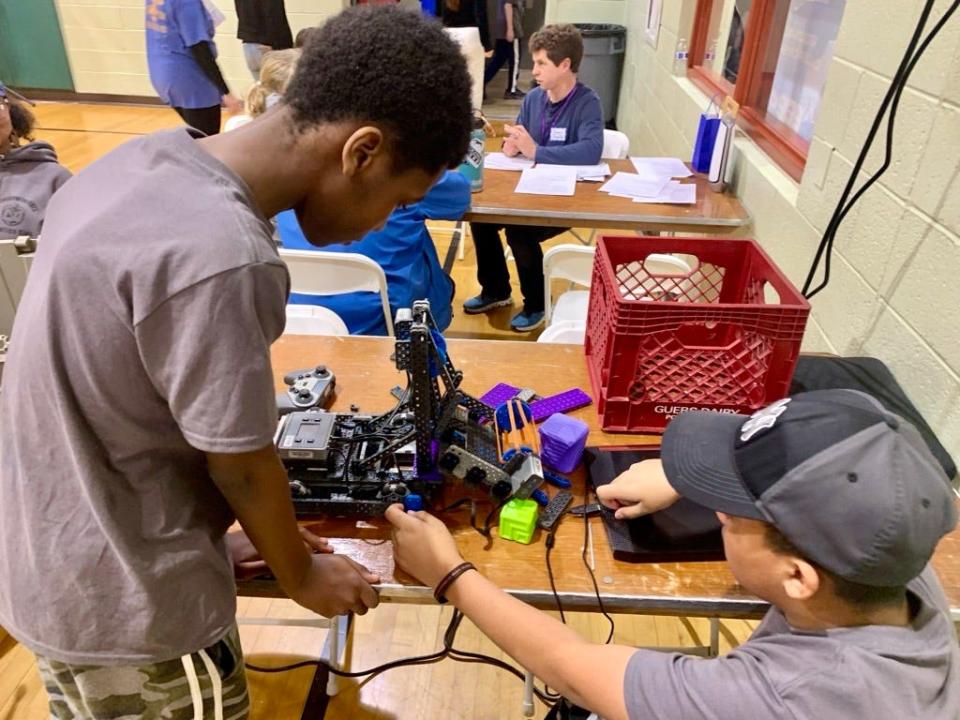 Keyon Hollis and John Paul Leonardo, sixth-grade students at Urban Promise Elementary in Wilmington, take a look at their robot on a break from competing at the VEX IQ Robotics Competition on Feb. 25, 2024.