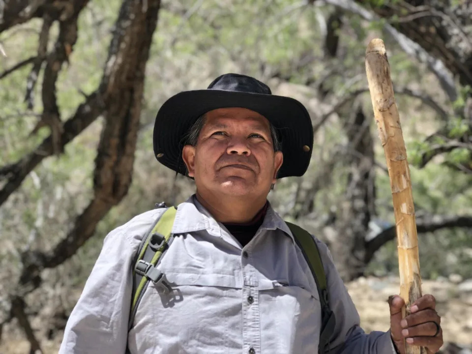 Thomas Tortez, wearing a hat and carrying a walking stick.