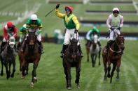 <p>Jockey Robbie Power (centre) celebrates after his winning ride on Sizing John in the Timico Cheltenham Gold Cup Chase </p>