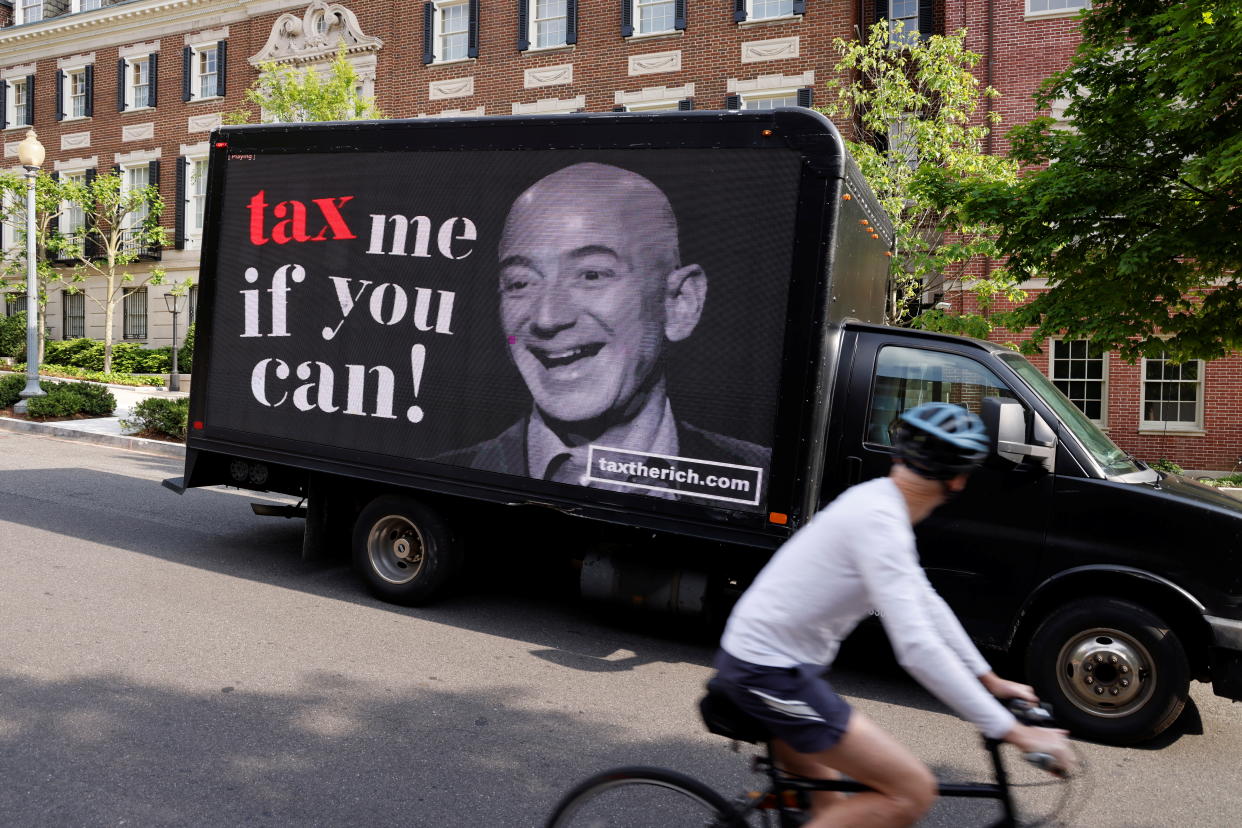 A video protest sign on a truck paid for by the Patriotic Millionaires drives past a mansion owned by Amazon founder Jeff Bezos as part of a federal tax filing day protest to demand he pay his fair share of taxes, in Washington, U.S. May 17, 2021.  REUTERS/Jonathan Ernst