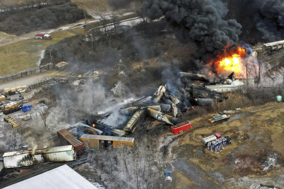 Debris from a Norfolk Southern freight train lies scattered and burning along the tracks on Feb. 4, 2023, the day after it derailed in East Palestine, Ohio. (AP Photo/Gene J. Puskar)