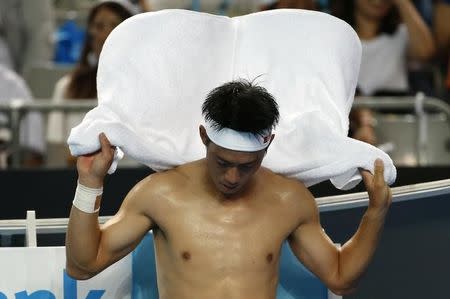 Japan's Kei Nishikori wipes himself with a towel during his fourth round match against France's Jo-Wilfried Tsonga at the Australian Open tennis tournament at Melbourne Park, Australia, January 24, 2016. REUTERS/Issei Kato