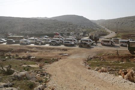 Fighters from a coalition of rebel groups called "Jaish al Fatah", also known as "Army of Fatah" (Conquest Army), escort Syrian Arab Red Crescent ambulances and buses evacuating fighters and civilians from the two besieged Shi'ite towns of al-Foua and Kefraya in the mainly rebel-held northwestern province of Idlib, and heading to cross to Turkey from the Syrian-Turkish border crossing of Bab al-Hawa, December 28, 2015. REUTERS/Khalil Ashawi