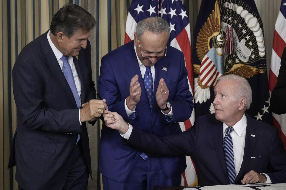 WASHINGTON, DC - AUGUST 16: U.S. President Joe Biden (R) gives Sen. Joe Manchin (D-WV) (L) the pen he used to sign The Inflation Reduction Act with Senate Majority Leader Charles Schumer (D-NY) in the State Dining Room of the White House August 16, 2022 in Washington, DC. The $737 billion bill focuses on climate change, lower health care costs and creating clean energy jobs by enacting a 15% corporate minimum tax, a 1-percent fee on stock buybacks and enhancing IRS enforcement. (Photo by Drew Angerer/Getty Images)