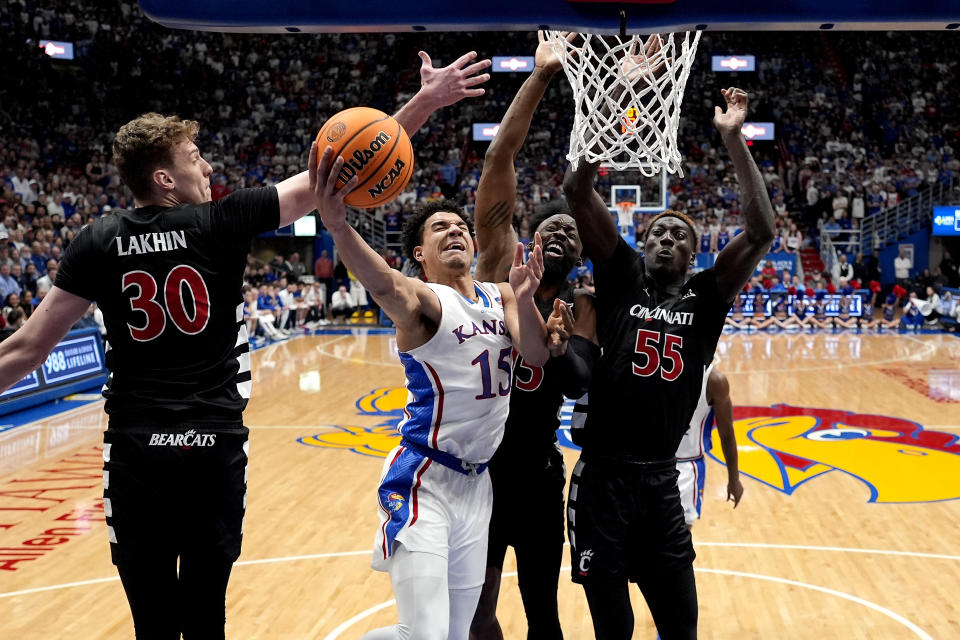 Kansas guard Kevin McCullar Jr. (15) gets past Cincinnati forward Viktor Lakhin (30) to put up a shot during the first half of an NCAA college basketball game Monday, Jan. 22, 2024, in Lawrence, Kan. (AP Photo/Charlie Riedel)