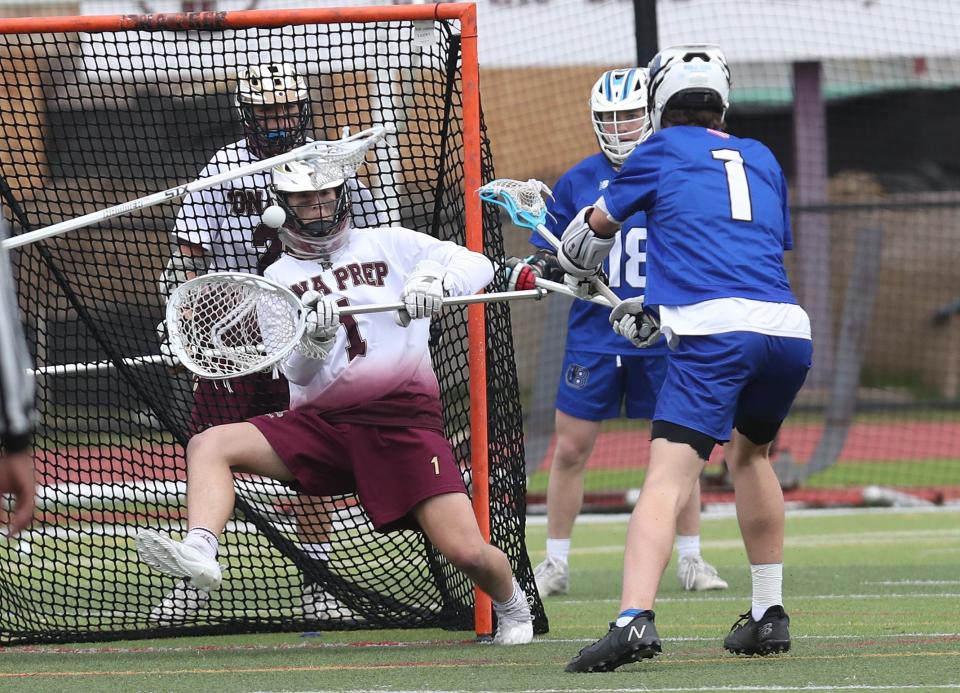 From right, Bronxville's Luke Stephens (1) gets a shot by Iona goalie Craig Daria (1) for a first half goal during boys lacrosse action at Iona Prep in New Rochelle March 31, 2022. Bronxville won the game in double overtime 7-6.