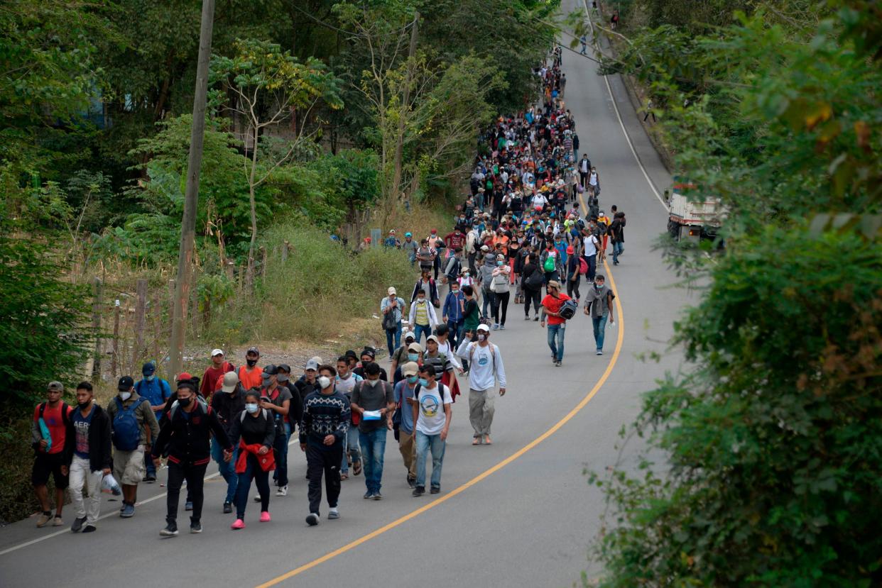 Honduran migrants, part of a caravan heading to the United States, walk along a road in Camotan, Guatemala on 16 January, 2021. (AFP via Getty Images)