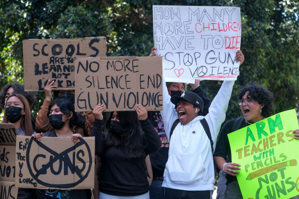 a crowd yelling and holding signs